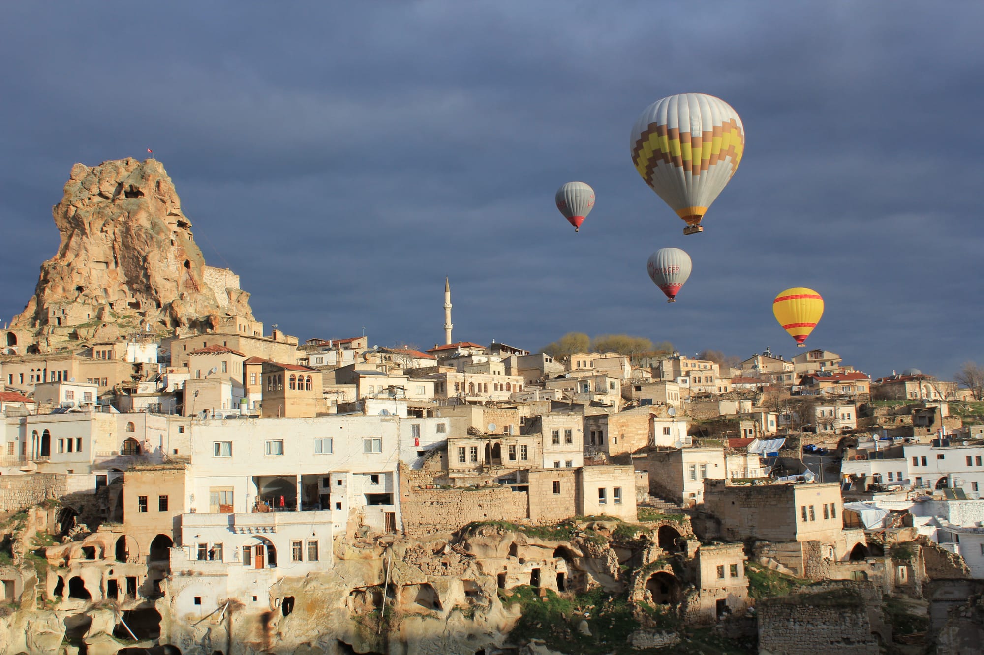 Hot air balloons drifting over Ortahisar castle in Cappadocia